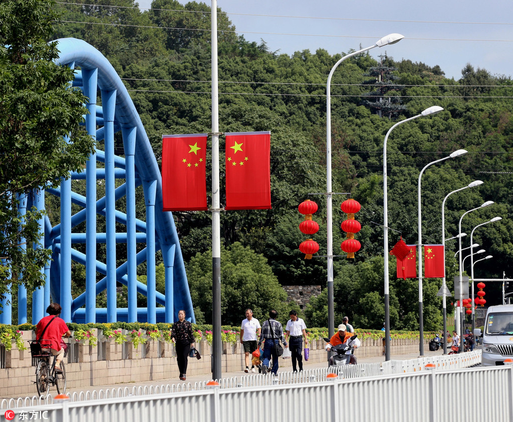 国庆氛围渐浓 国旗,中国结和红灯笼等中国元素遍布街头